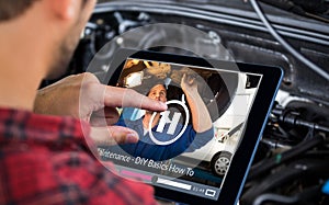 Composite image of man using tablet on wooden table