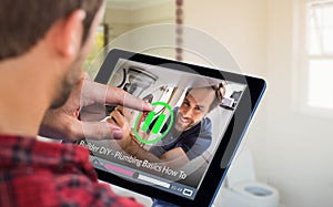 Composite image of man using tablet on wooden table