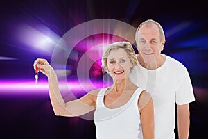 Composite image of mature couple smiling at camera with new house key