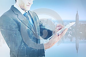 Composite image of mid section of a businessman using digital tablet