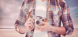 Composite image of mid section of hipster using camera