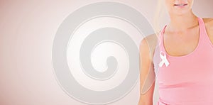 Composite image of mid section of woman wearing breast cancer awareness ribbon