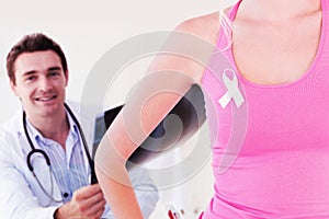 Composite image of mid section of woman wearing ribbon for breast cancer awareness