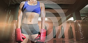 Composite image of midsection of female boxer with gloves