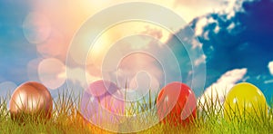 Composite image of mulit colored shiny easter eggs on grass