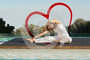 Composite image of peaceful brunette in janu sirsasana yoga pose poolside