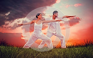 Composite image of peaceful couple in white doing yoga together in warrior position