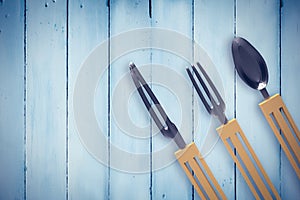 Composite image of plastic knife, fork and spoon