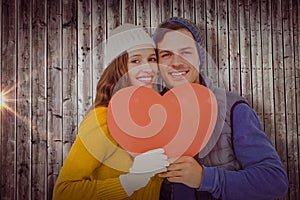 Composite image of portarit of happy couple holding paper heart