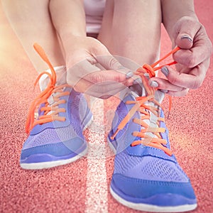 Composite image of portrait of athlete woman tying her running shoes