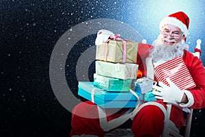 Composite image of portrait of cheerful santa claus holding christmas presents on chair