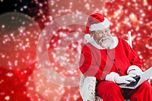 Composite image of portrait of cheerful santa claus typing on laptop