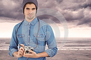 Composite image of portrait of confident hipster using camera