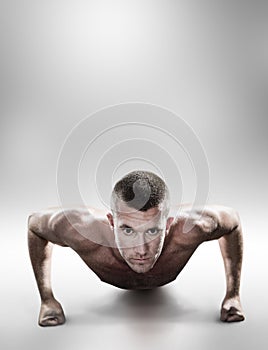 Composite image of portrait of confident shirtless man doing push ups