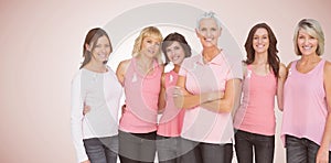 Composite image of portrait of confident women supporting breast cancer awareness