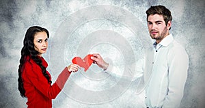 Composite image of portrait of couple holding red cracked heart shape