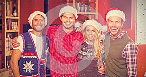 Composite image of portrait of friends wearing christmas hats