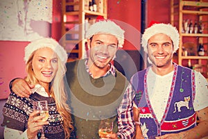 Composite image of portrait of friends wearing christmas hats