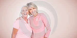 Composite image of portrait of happy daughter with mother supporting breast cancer awareness