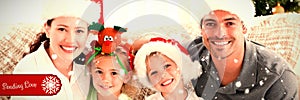 Composite image of portrait of a happy family with christmas hats sitting on the sofa