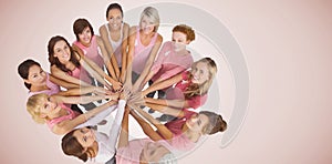 Composite image of portrait of happy female friends supporting breast cancer awareness