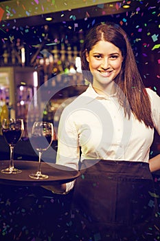 Composite image of portrait of pretty waitress serving red wine