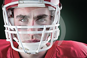 Composite image of portrait of a serious american football player taking his helmet looking at camer