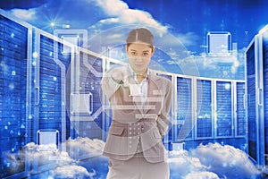 Composite image of portrait of a serious businesswoman pointing at the viewer