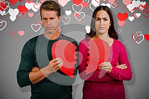 Composite image of portrait of serious couple holding cracked heart shape