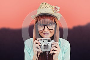 Composite image of portrait of a smiling hipster woman holding retro camera