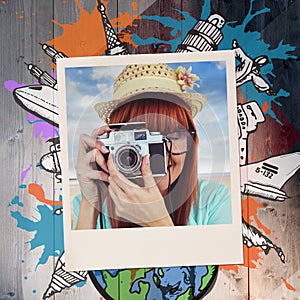 Composite image of portrait of a smiling hipster woman holding retro camera