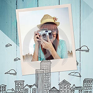 Composite image of portrait of a smiling hipster woman holding retro camera