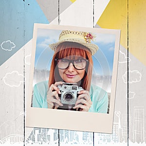 Composite image of portrait of a smiling hipster woman holding retro camera