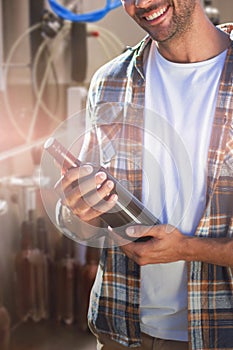 Composite image of portrait of smiling young man holding wine bottle