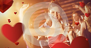 Composite image of portrait of young woman holding glass of champagne while dancing