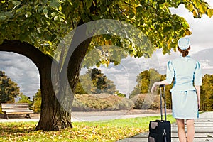 Composite image of pretty air hostess leaning on suitcase