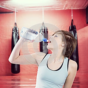 Composite image of pretty brunette drinking water