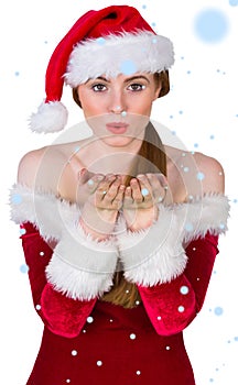 Composite image of pretty girl in santa costume blowing at camera