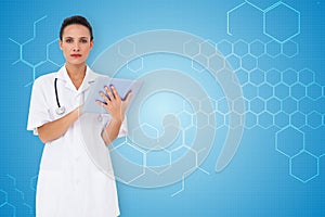 Composite image of pretty nurse using tablet pc