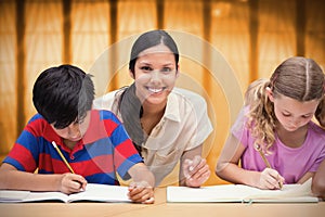 Composite image of pretty teacher helping pupils in library