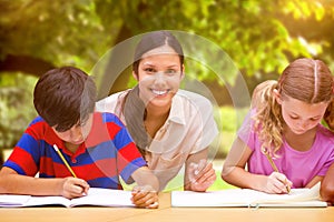 Composite image of pretty teacher helping pupils in library