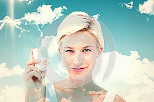 Composite image of pretty woman holding inhaler smiling at camera