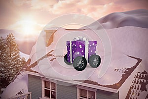 Composite image of purple wrapped with polka dot gift box on wheels