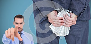 Composite image of rear view of businessman with handcuff and money