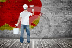 Composite image of rear view of man using paint roller