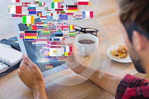 Composite image of rear view of man using tablet on wooden table