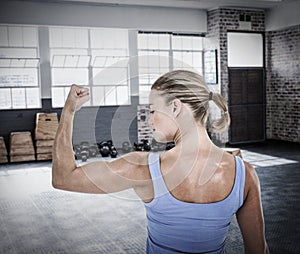 Composite image of rear view of muscular woman flexing muscles