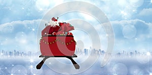 Composite image of rear view of santa claus riding on sled with gift box