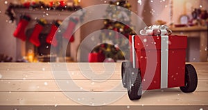 Composite image of red gift box on wheels