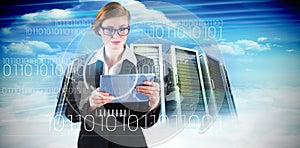 Composite image of redhead businesswoman using her tablet pc